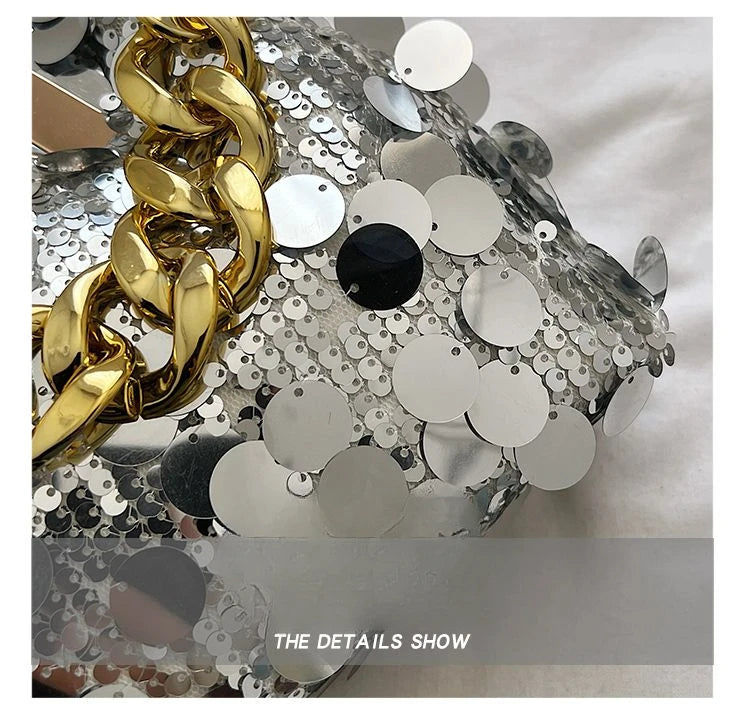 Close-up of a decorative object with gold chain and silver sequins on a white background.