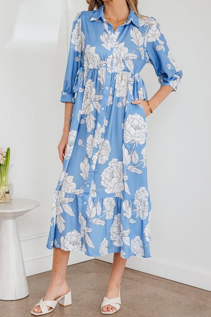 Robe longue bleu ciel à imprimé floral, col boutonné, manches 3/4 et ourlet à volants