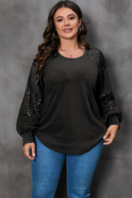 Woman wearing a black top with sequin sleeves against a gray background